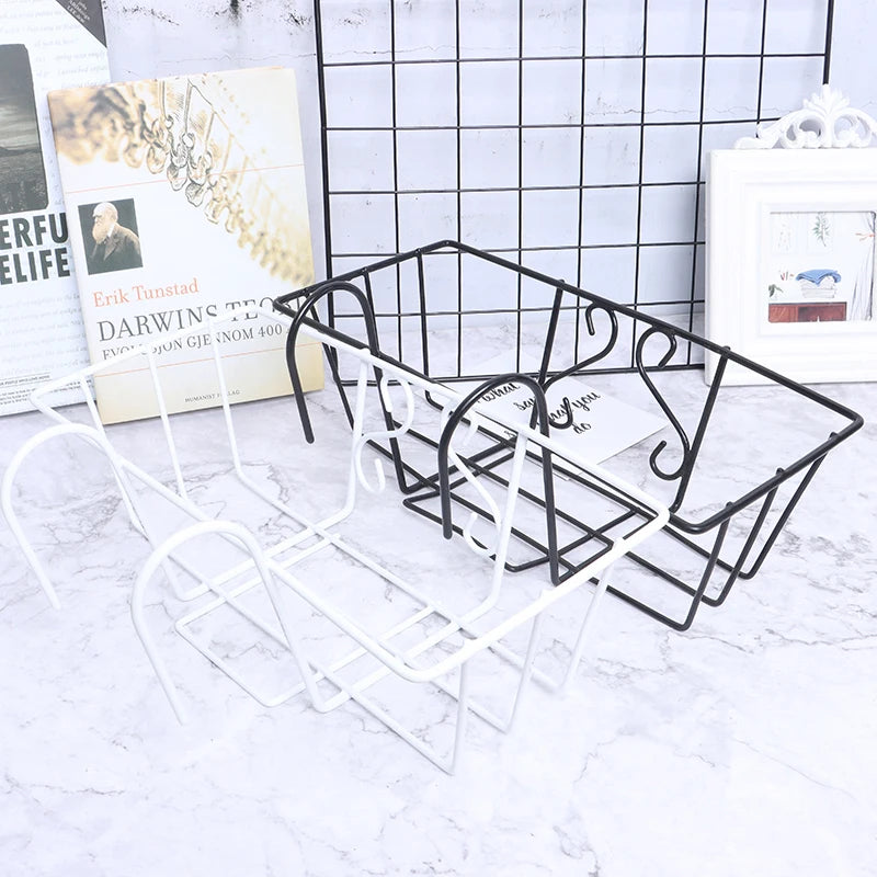 Side view of black and white wire hanging baskets with hooks, staged with books and a grid wall