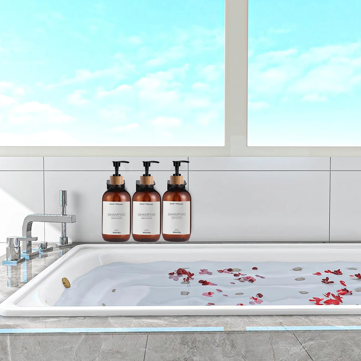 Three amber pump bottles lined up on the edge of a bathtub with blue sky visible through the window