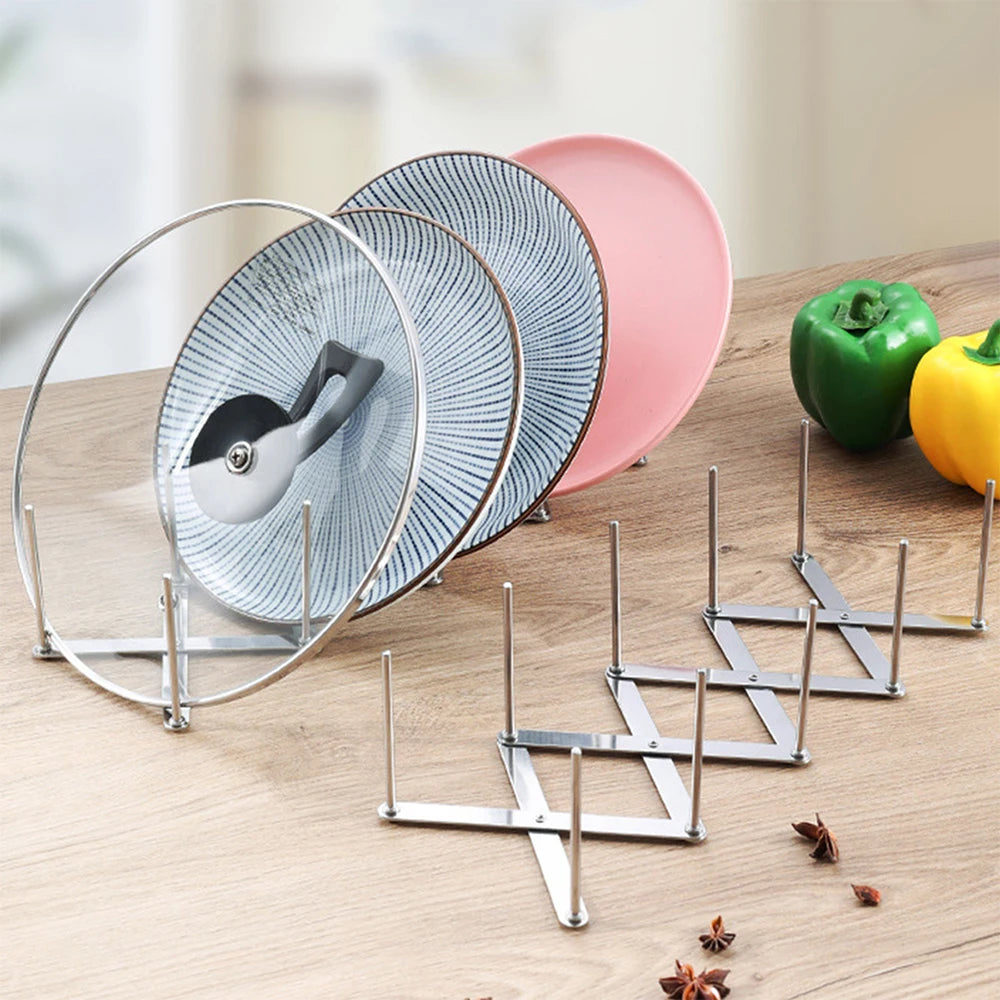 Retractable stainless steel organizer rack holding pot lids and plates on a wooden kitchen counter