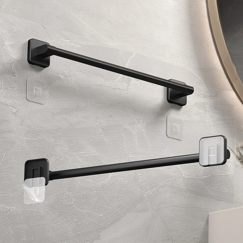 Close-up of black self-adhesive towel bars installed by a bathroom mirror
