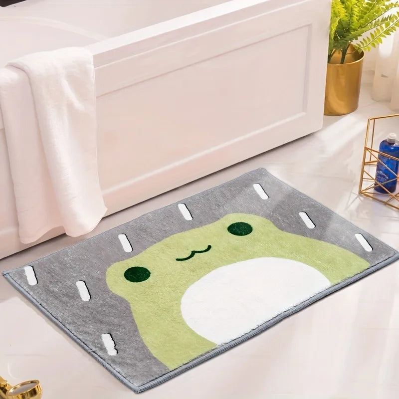 Frog bath rug placed next to a white bathtub with a gold plant holder and towel