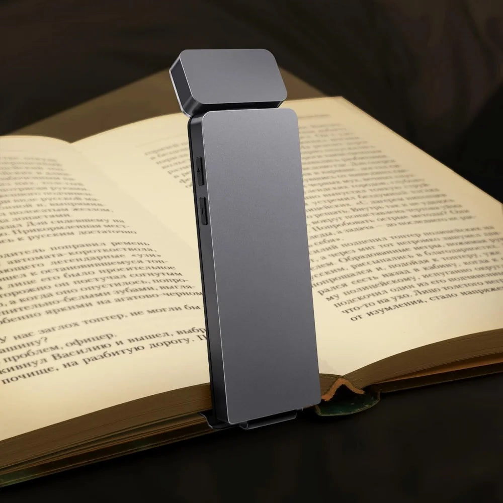 Clip-on USB reading light attached to an open book during nighttime reading