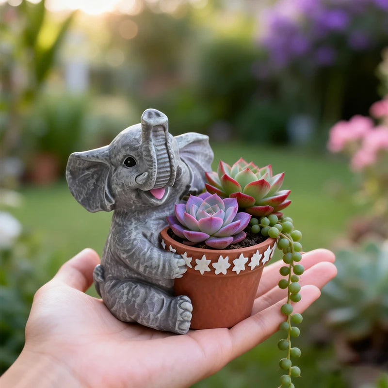 Gray elephant succulent planter held in hand, showing small size and detail, in a garden setting