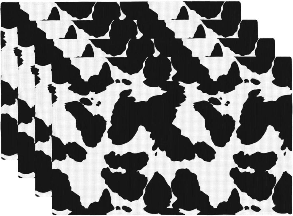 White background with bold black cow spot print placemats, stacked display
