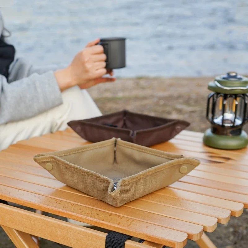Brown and khaki snap-tray organizers on a campsite table with coffee