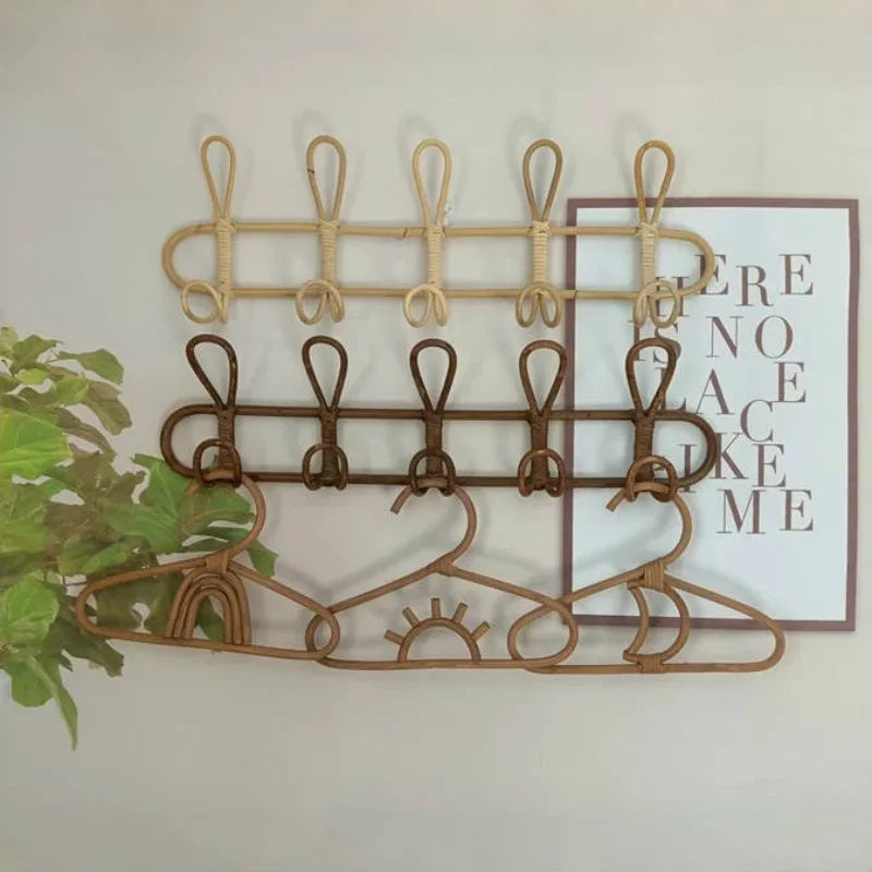 Two wall-mounted rattan hook racks and playful rattan hangers in kids room setting