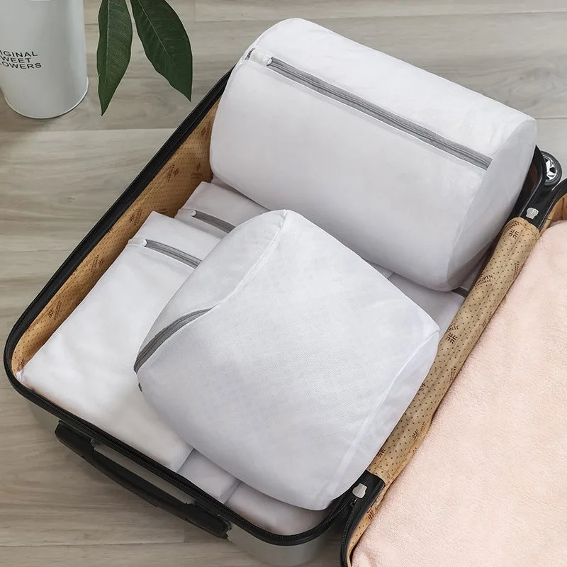 Mesh laundry bags, including the cylindrical shoe bag, neatly packed inside an open suitcase