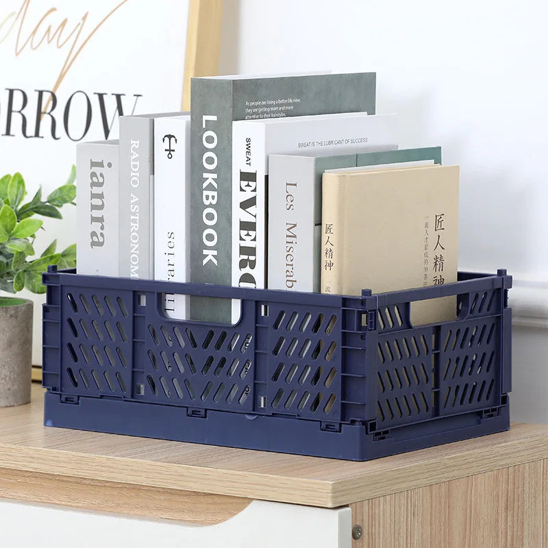 Navy blue foldable storage crate used as a desktop organizer for books