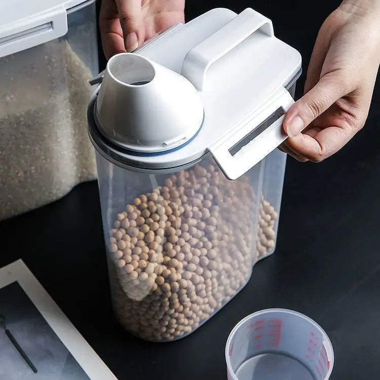 Close-up of a clear airtight pet food storage container with white lid and measuring cup