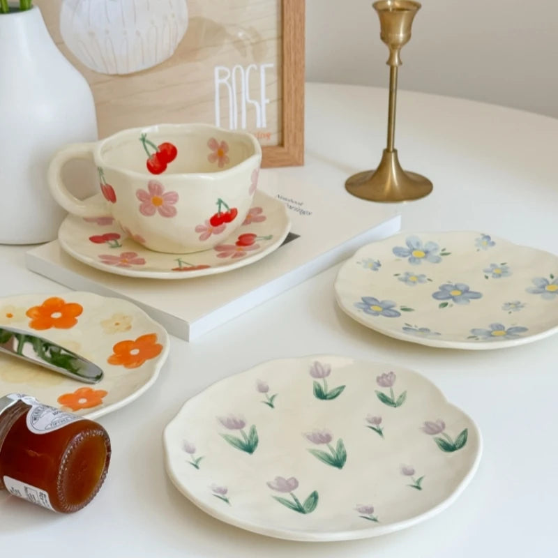 Hand-painted ceramic plates in various flower designs displayed on a cozy coffee table