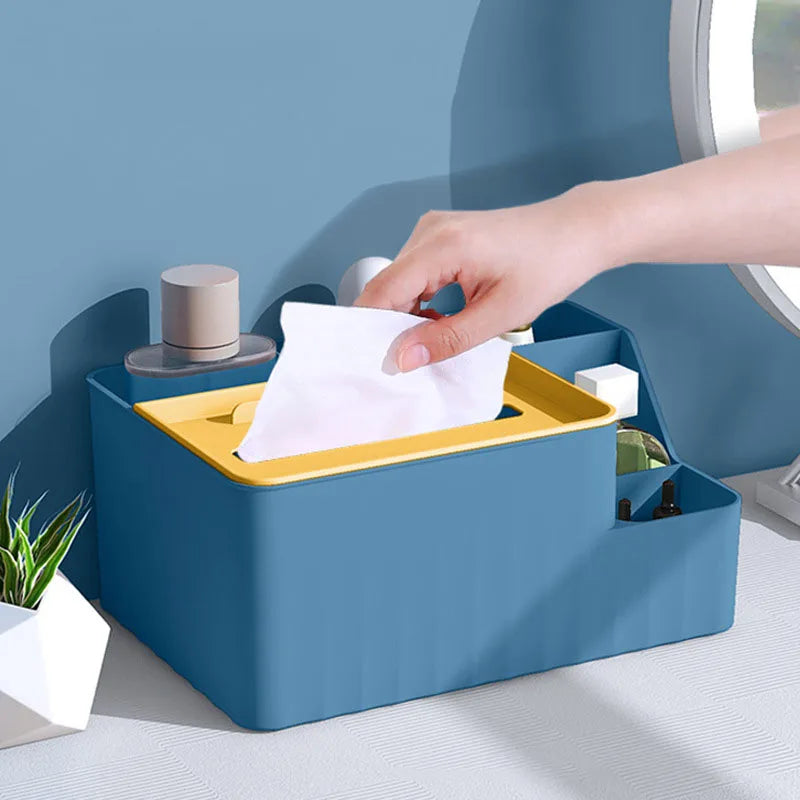 Blue and yellow organizer on a vanity with a hand pulling a tissue from the box section.