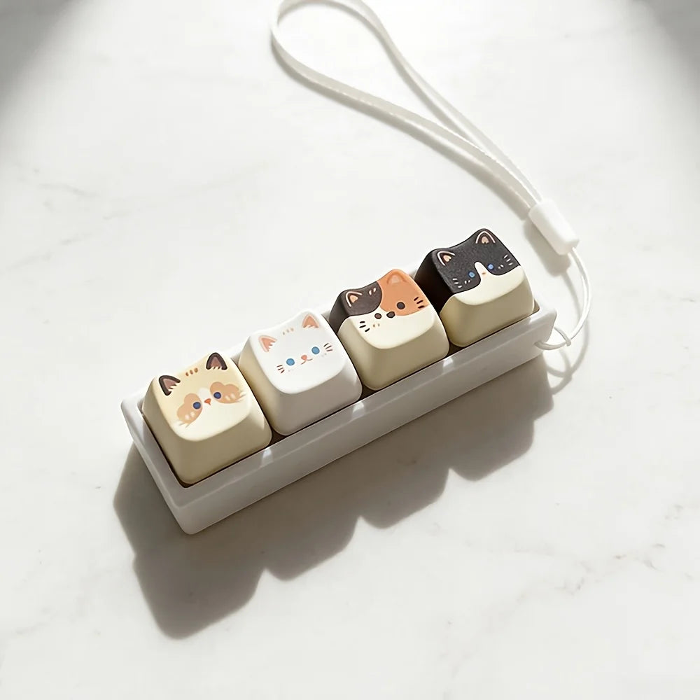 Cat key lanyard with four cat face buttons and white nylon loop on marble surface