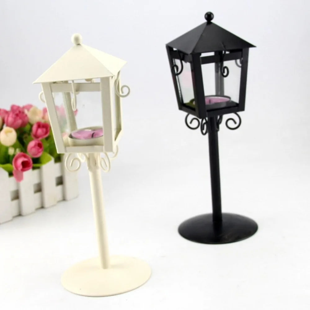 Two lantern-style iron candle holders in black and white on display