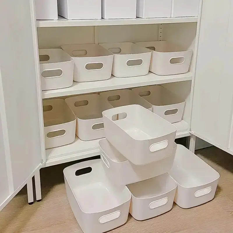 Set of white stackable plastic storage bins organized on cabinet shelves