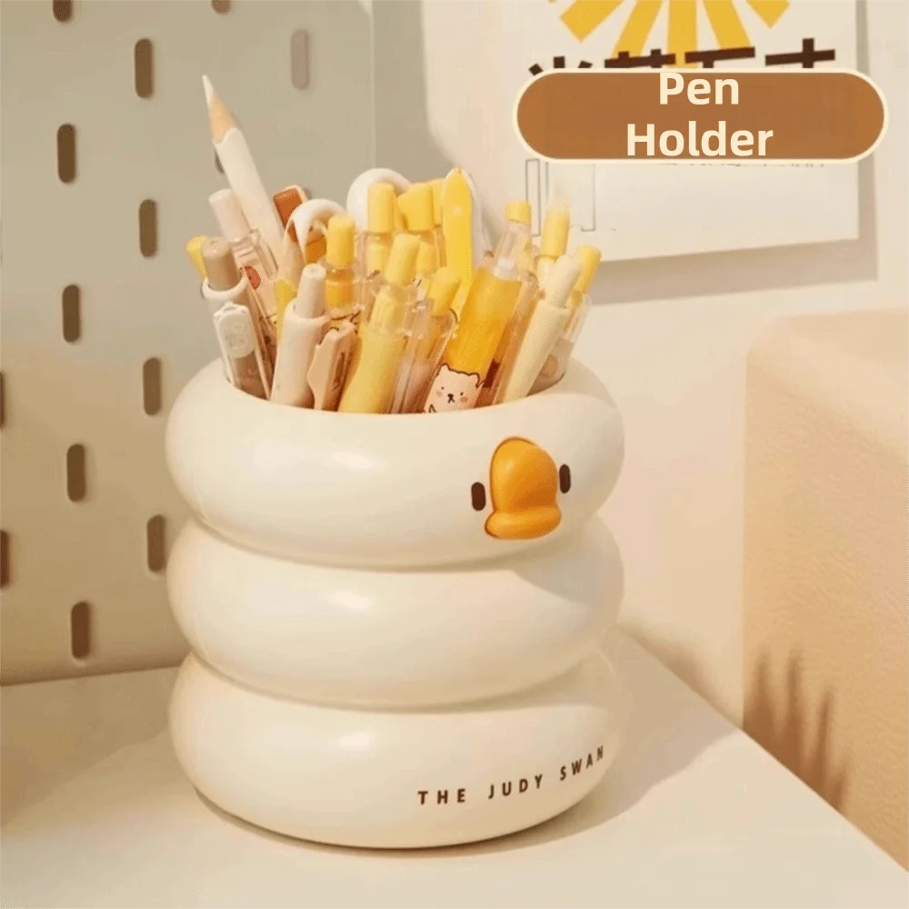 Cream duck-shaped desk organizer with yellow bill, holding pens and pencils