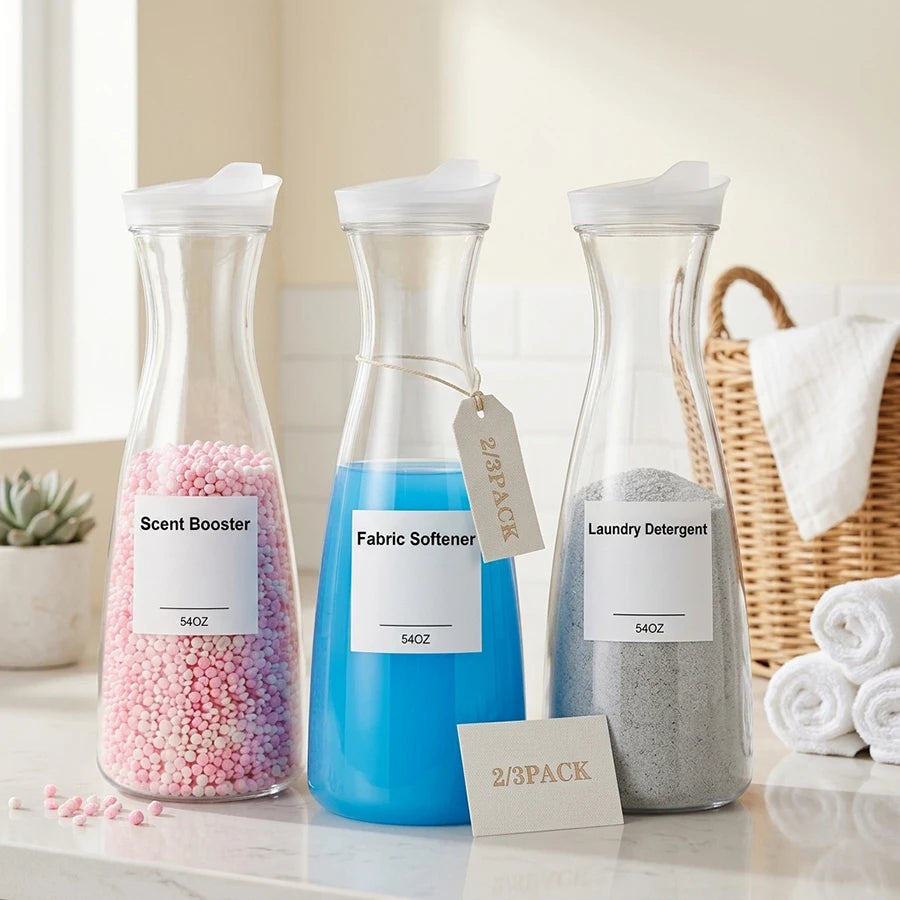 Set of three clear plastic laundry dispenser bottles labeled for scent booster, fabric softener, and laundry detergent on a laundry room counter