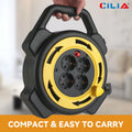 Retractable extension cord reel with carry handle and four EU sockets shown in hand in a living room