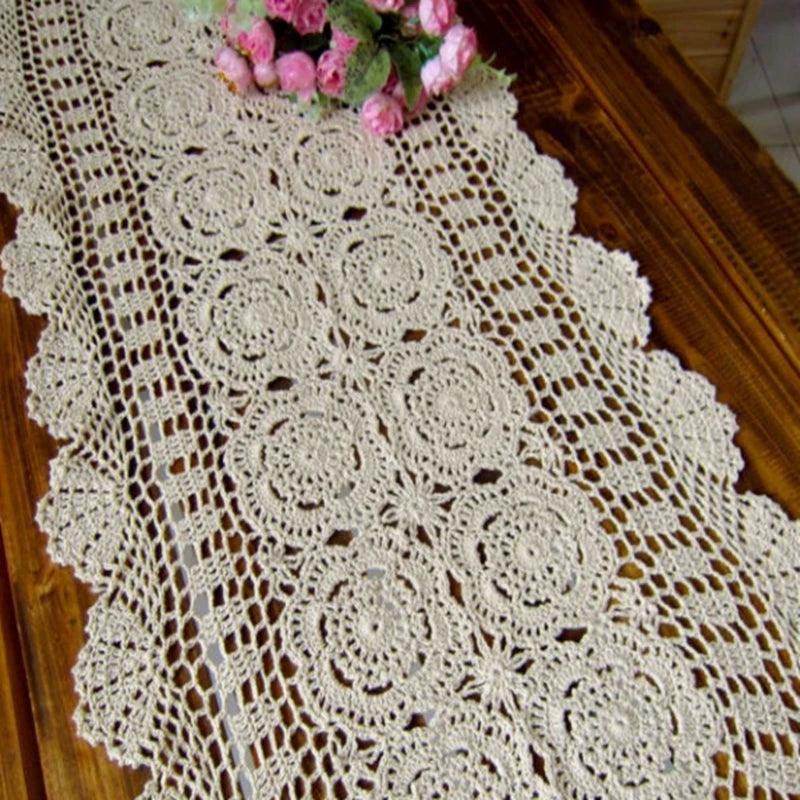 Close view of neutral beige cotton crochet table runner with intricate floral design