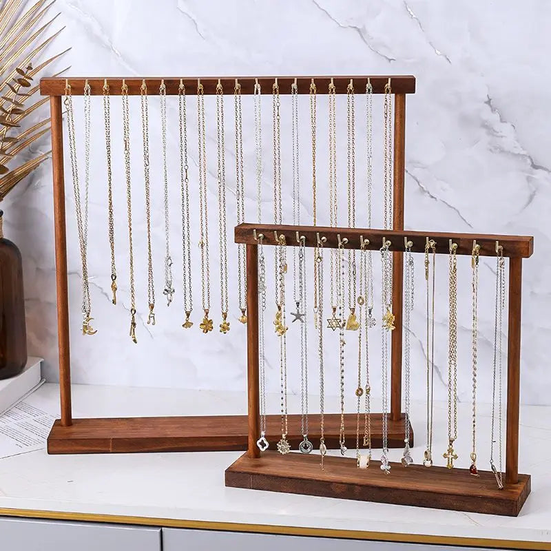 solid wood jewelry organizer stands with necklaces and bracelets displayed on a marble countertop