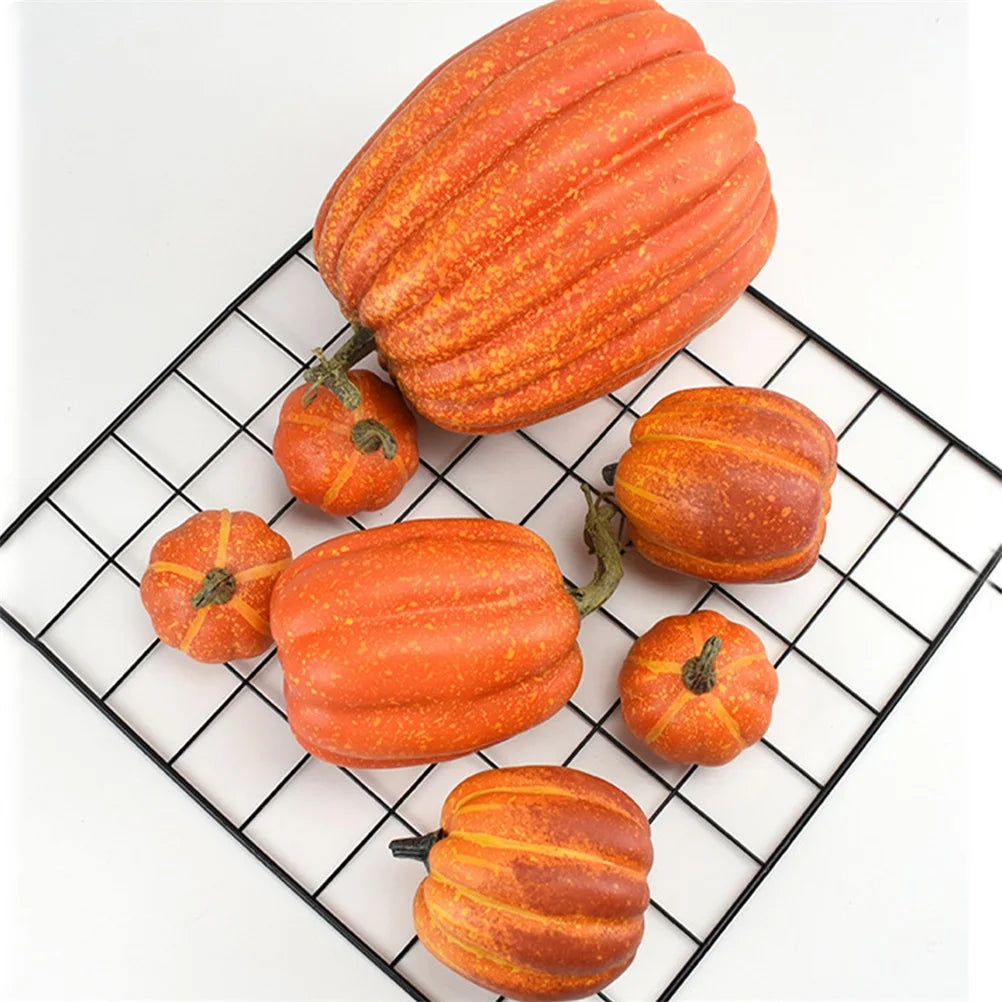 Assorted orange artificial pumpkins arranged on a wire tray, showing various shapes and sizes