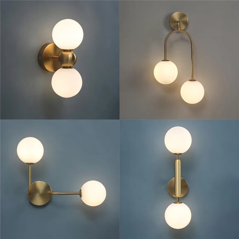 Assorted double globe modern wall sconces in brushed gold finish with frosted glass globes on blue wall