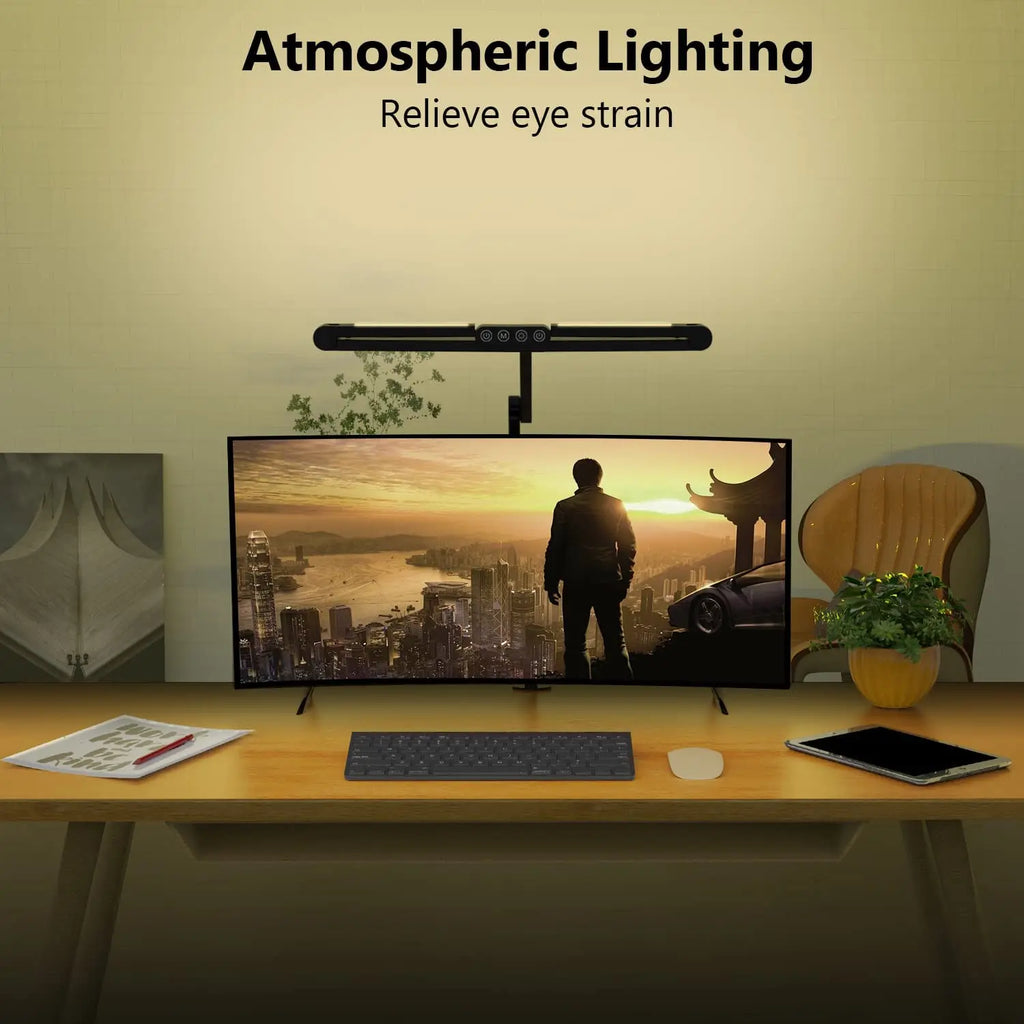 LED clamp desk lamp providing ambient lighting on a home office desk with a large monitor at night