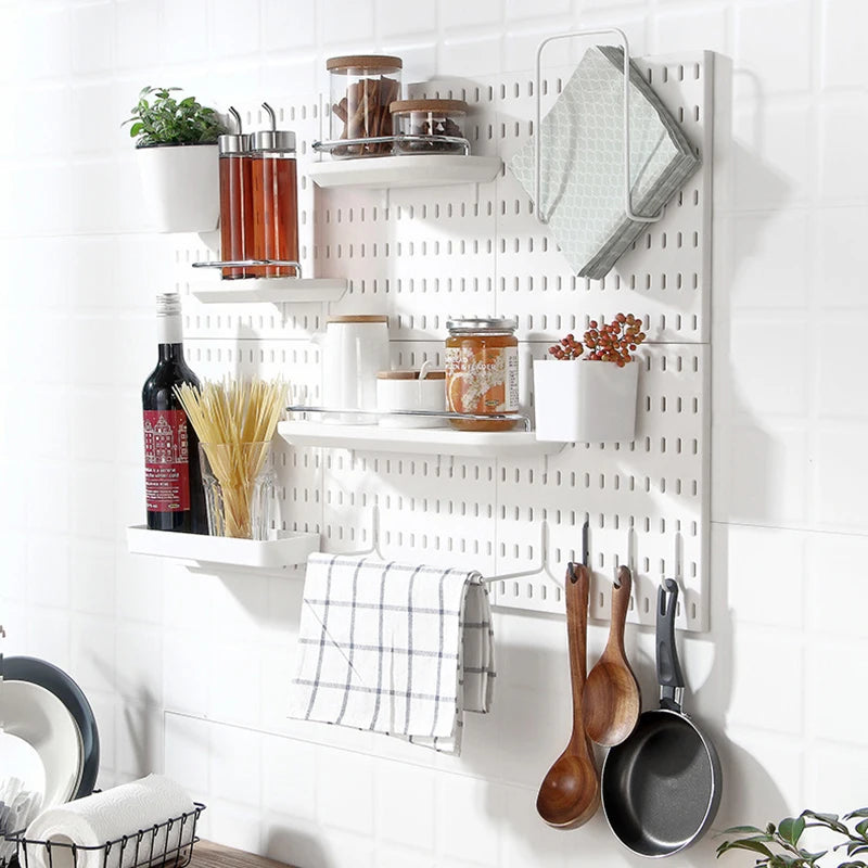 Pegboard wall in a kitchen with shelves, hooks, jars, and utensils neatly arranged