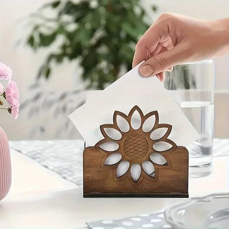 Hand placing a napkin into a wooden sunflower napkin holder on a set table