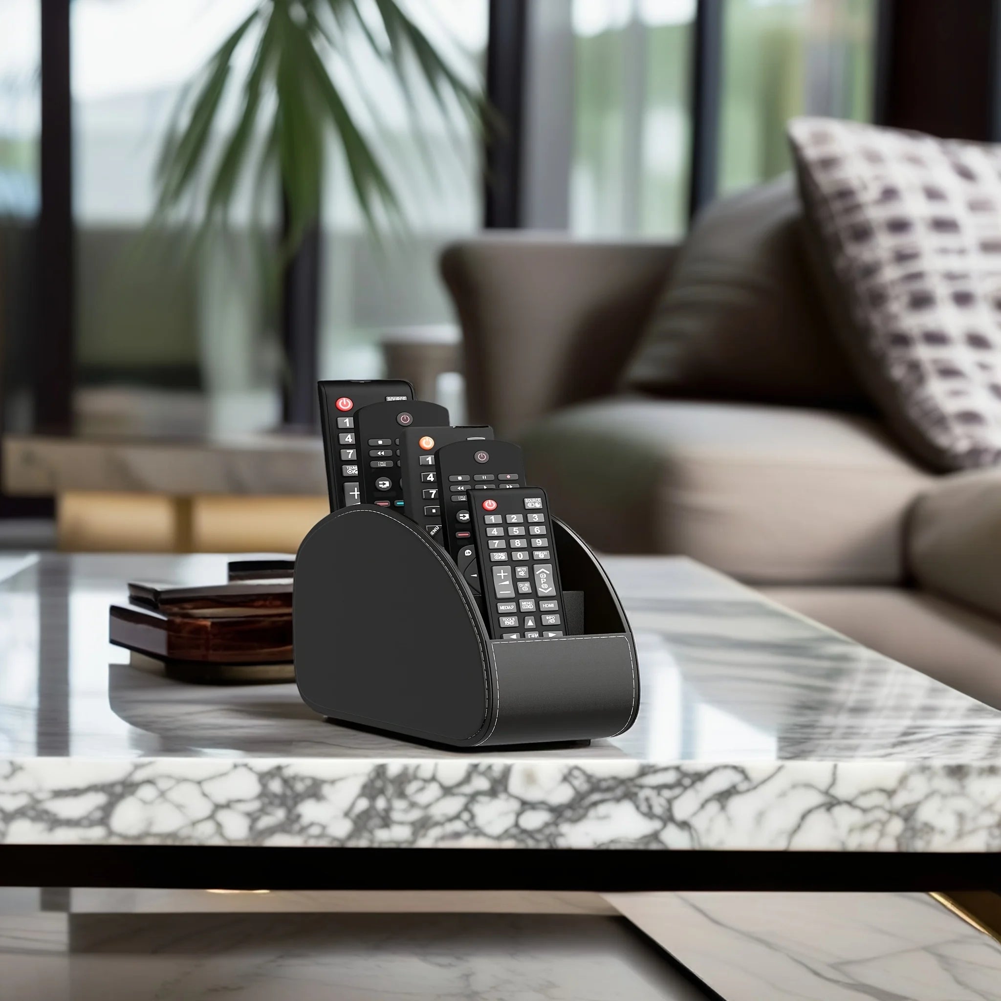 Black remote holder on a marble coffee table with remotes in a modern living room