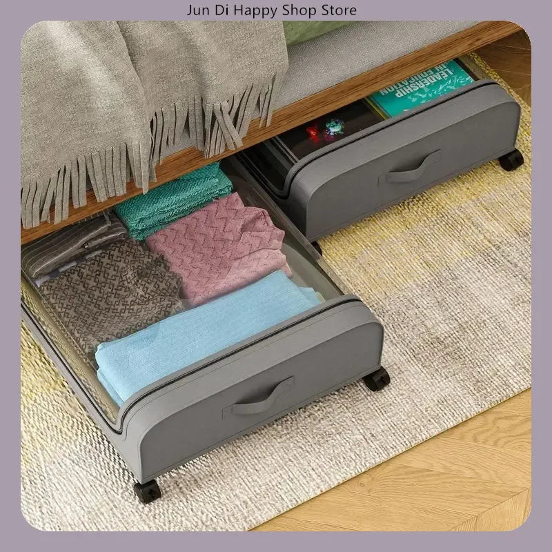 Gray rolling storage drawers under a bed, used to organize folded blankets and towels