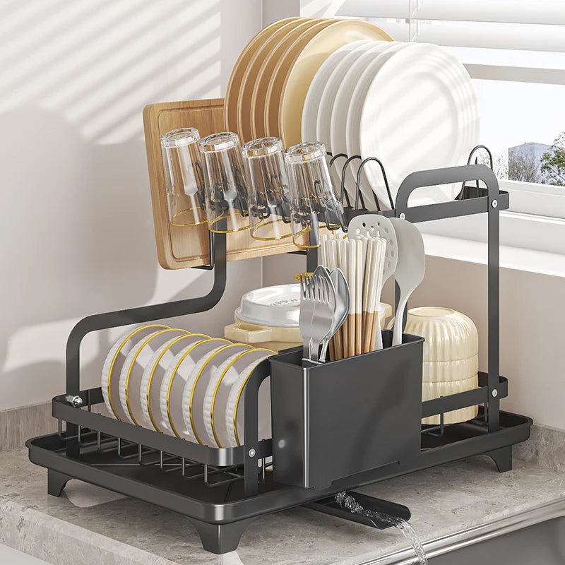 Side view of two-tier dish drying rack next to window with organized cutlery and dishes