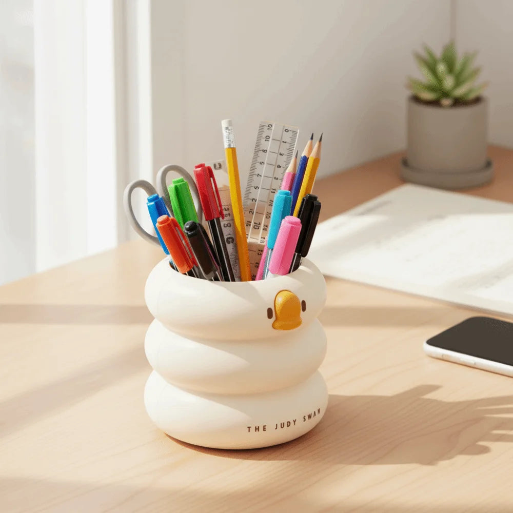 Duck-shaped plastic organizer filled with colorful pens, on a bright office desk