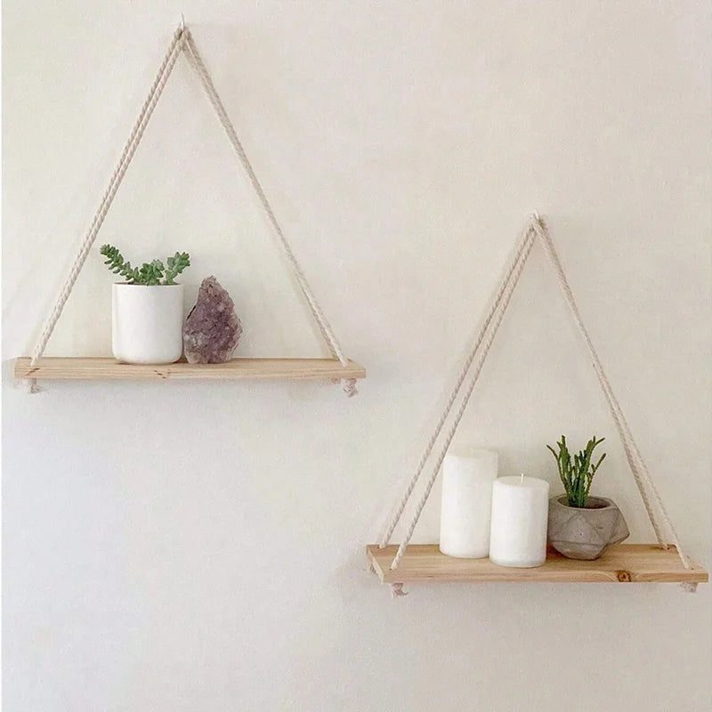 Two beige wood rope hanging wall shelves styled with plants and candles