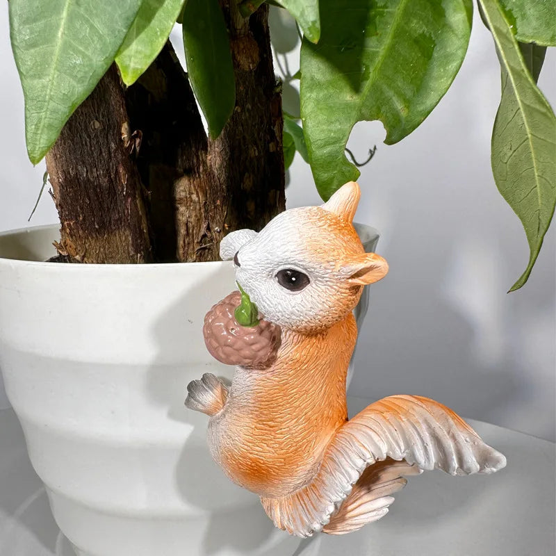 Single resin squirrel decoration perched on the edge of a white flower pot
