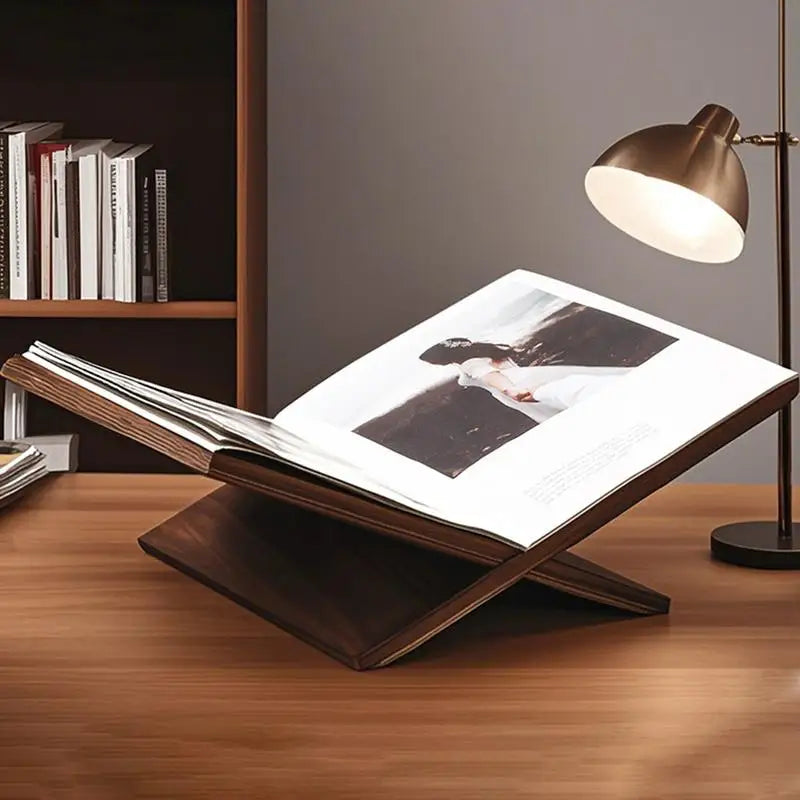 wooden book stand on a desk with a photo album open under a lamp
