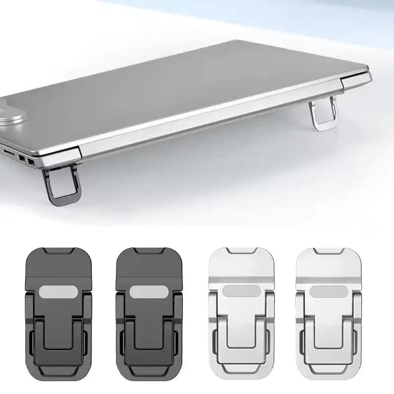 Mini foldable laptop risers in black and silver attached to a laptop raising the back edge on a white surface