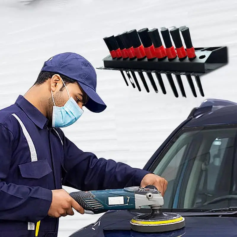worker using a power tool near a mounted spray bottle and brush rack in a workshop setting