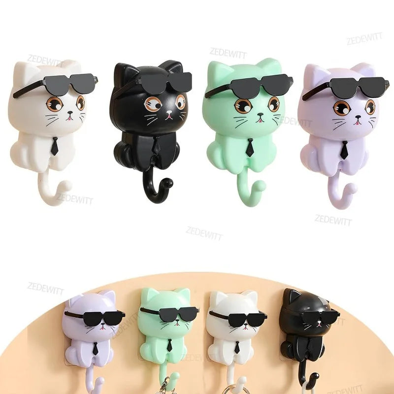 Four cat-shaped wall hooks in white, black, green, and purple, with sunglasses and ties, displayed individually and in use holding keys and bags