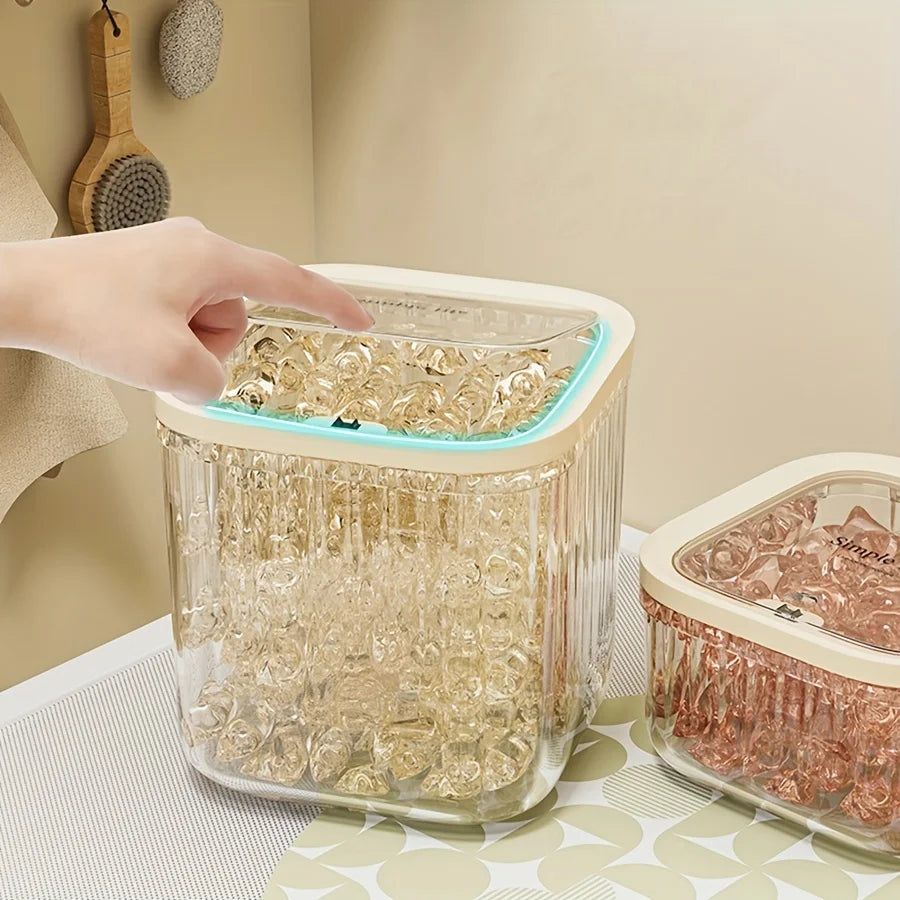 Person opening the lid of a clear square laundry storage bin full of capsules