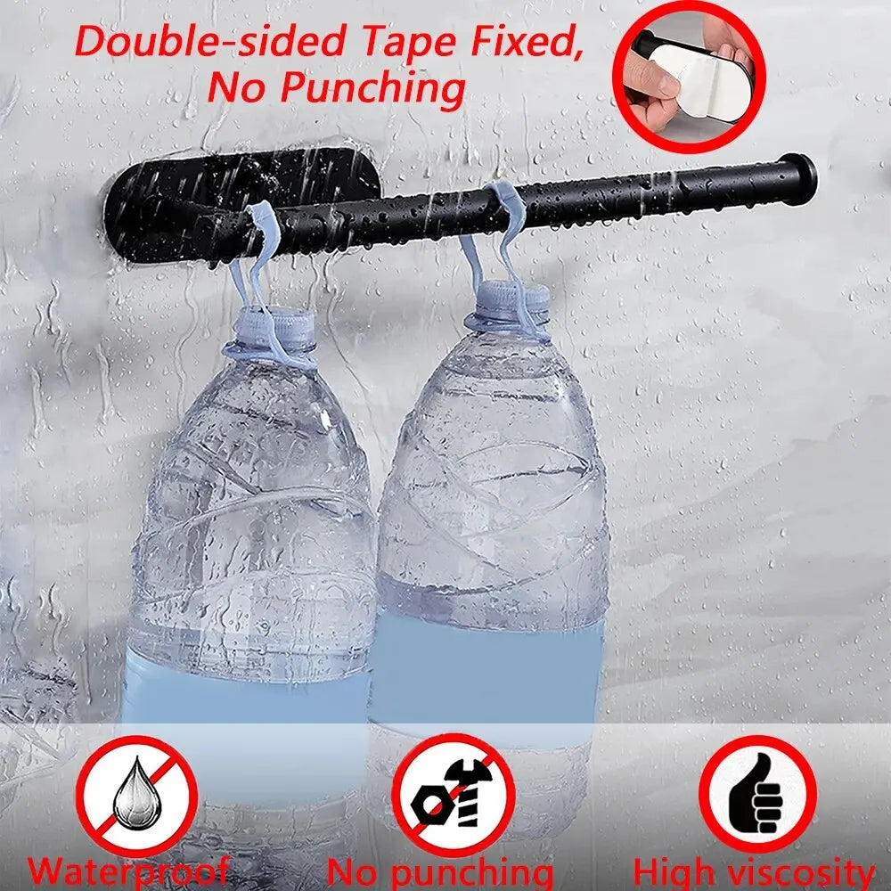 Black paper towel holder adhered to wet tiled wall, holding two large water bottles