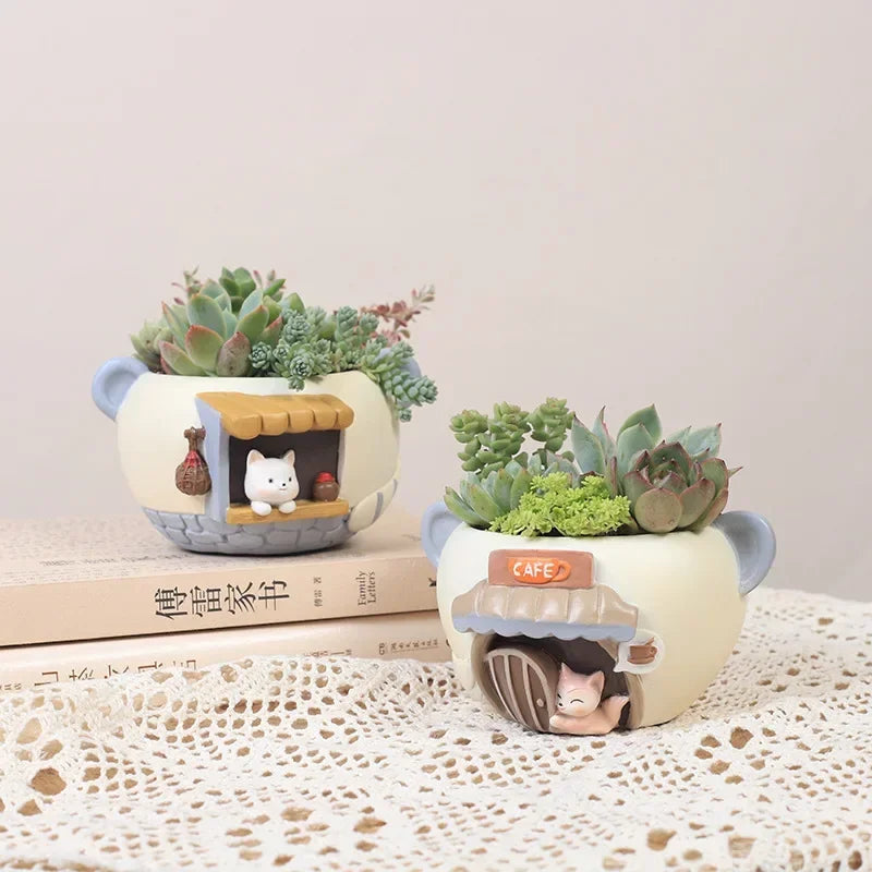 Kitten and fox animal resin planters displayed with succulents on books and lace table covering