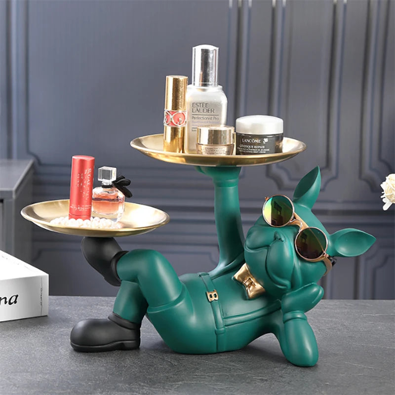 Green bulldog resin sculpture tray with sunglasses and gold trays, holding beauty items on a table