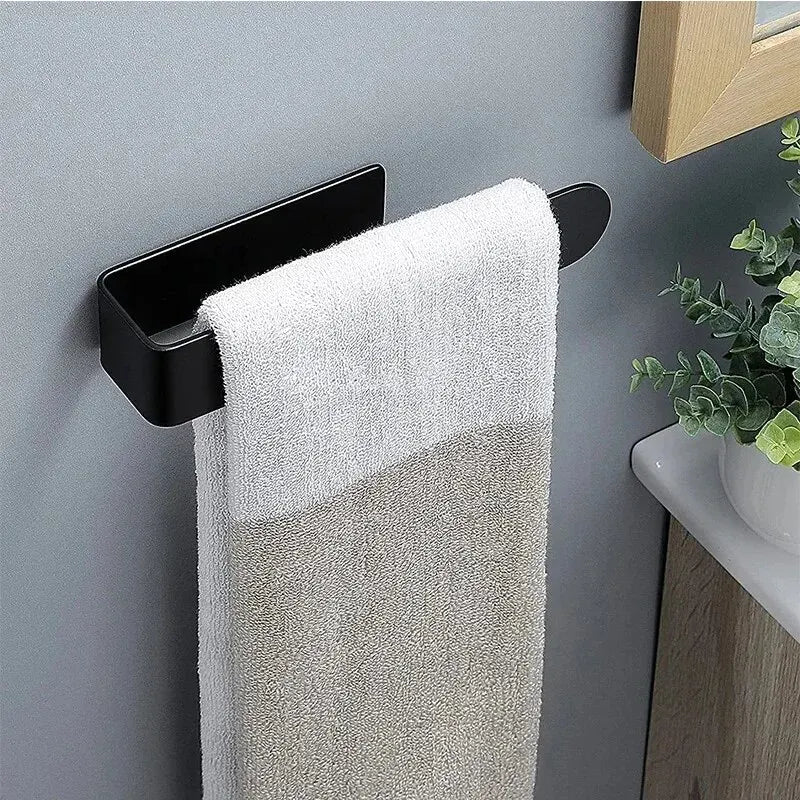 Compact black towel rack mounted on a wall with a hand towel in a bathroom setting