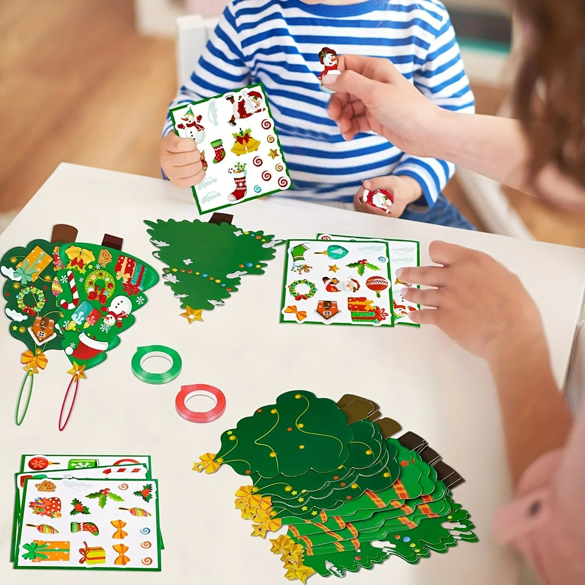 Parent and child using sticker sheets to decorate Christmas tree ornaments at a table
