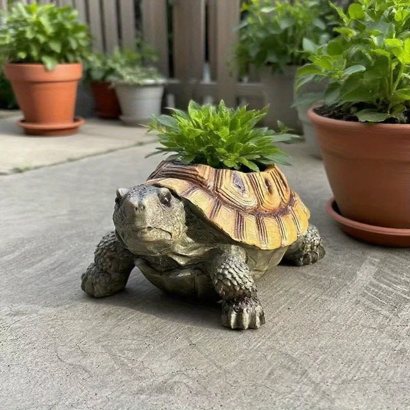 Resin turtle planter with a succulent among other pots on a patio