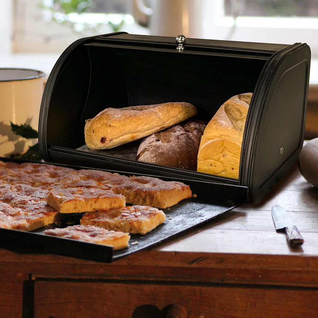 Open black metal bread box with fresh loaves and bread slices inside