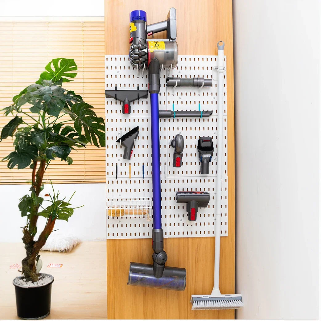 Pegboard wall with cleaning tools and vacuum attachments organized in a utility or laundry space