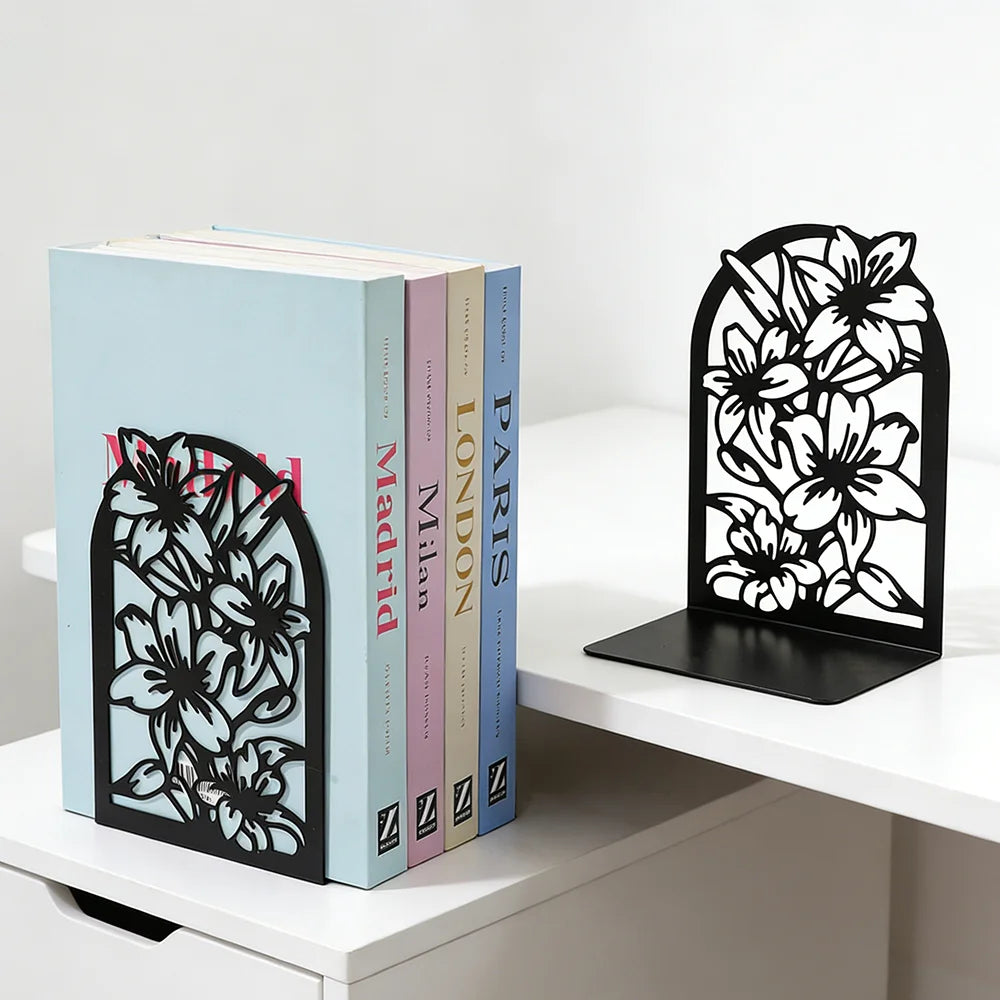 Black floral pattern bookends keeping books upright on a modern desk