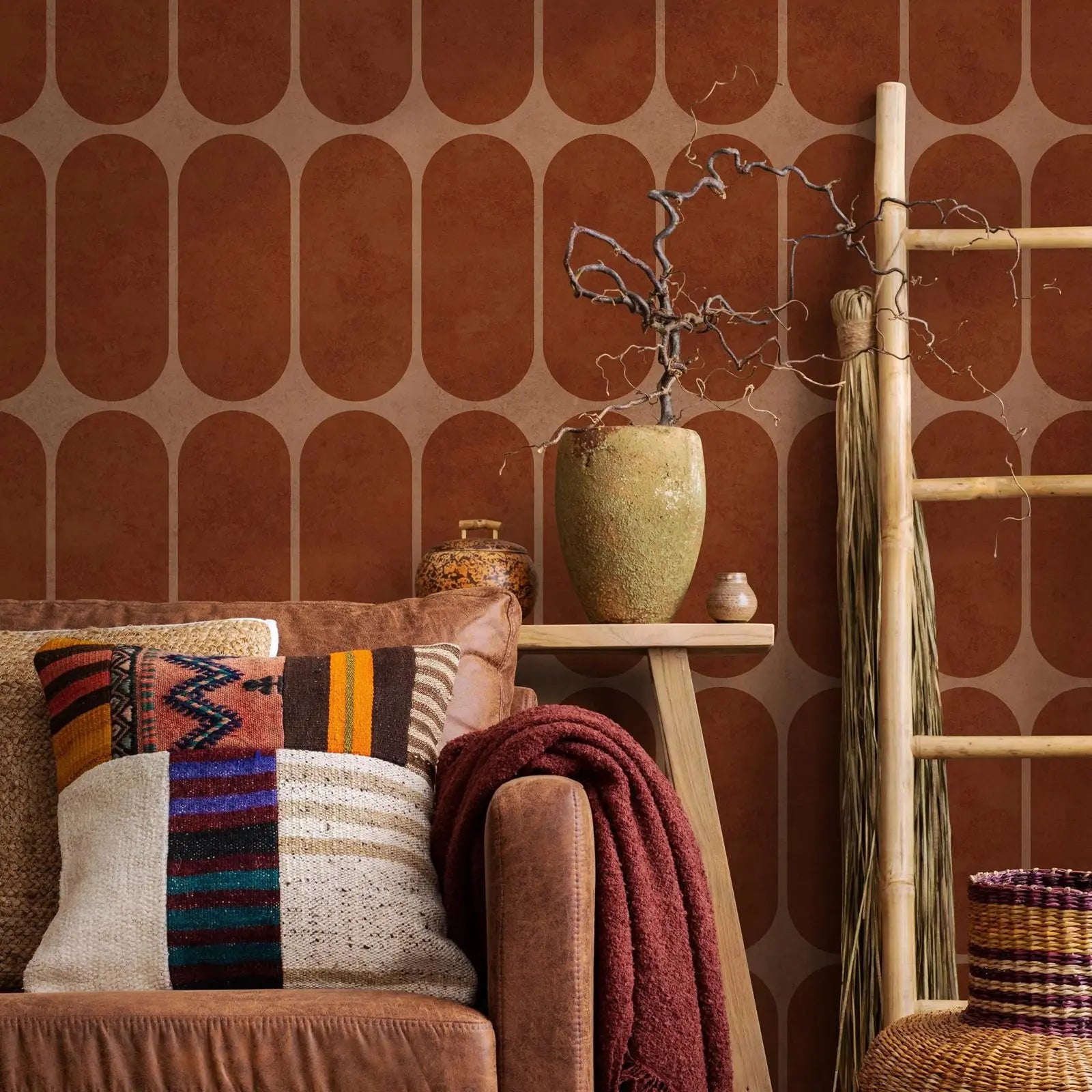 Terracotta arch geometric wallpaper behind cozy living room decor with ladder and textiles