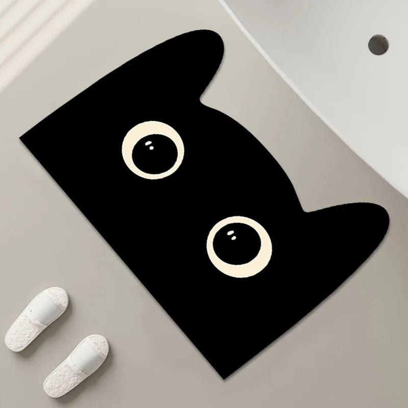 Rectangular black cat bath mat with large eyes, placed near a sink.
